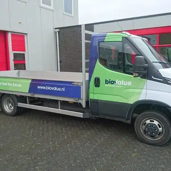 Bedrijfswagen met open laadbak en herkenbare voertuigreclame van BioValue, uitgevoerd in huisstijl door Dox.
