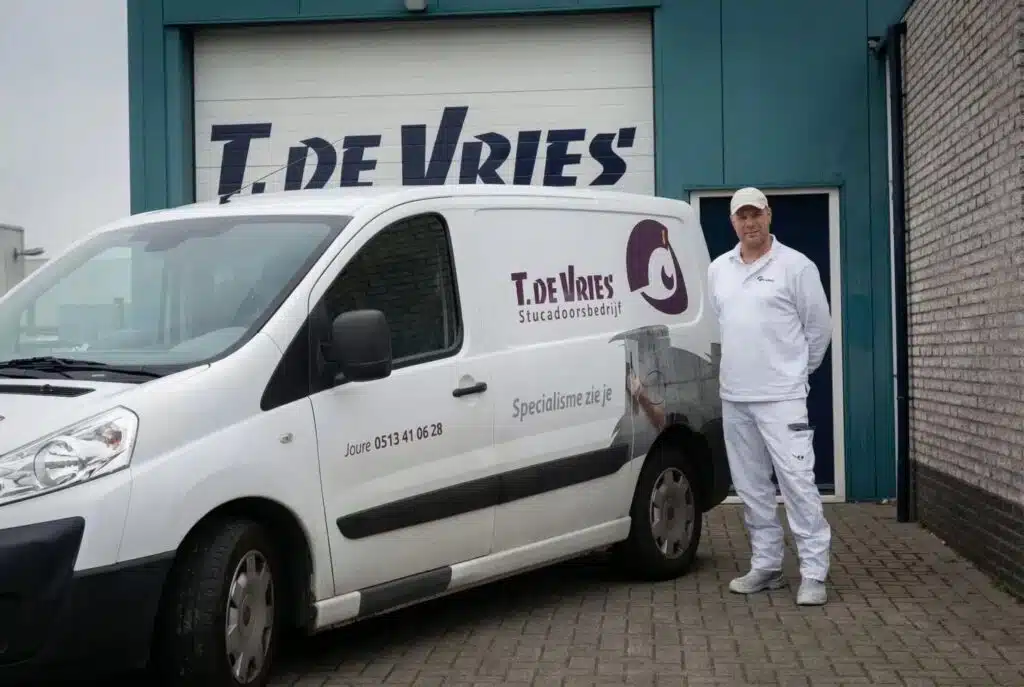 Witte bedrijfswagen met belettering van stucadoorsbedrijf T. de Vries uit Joure, voorzien van reclame door Dox.