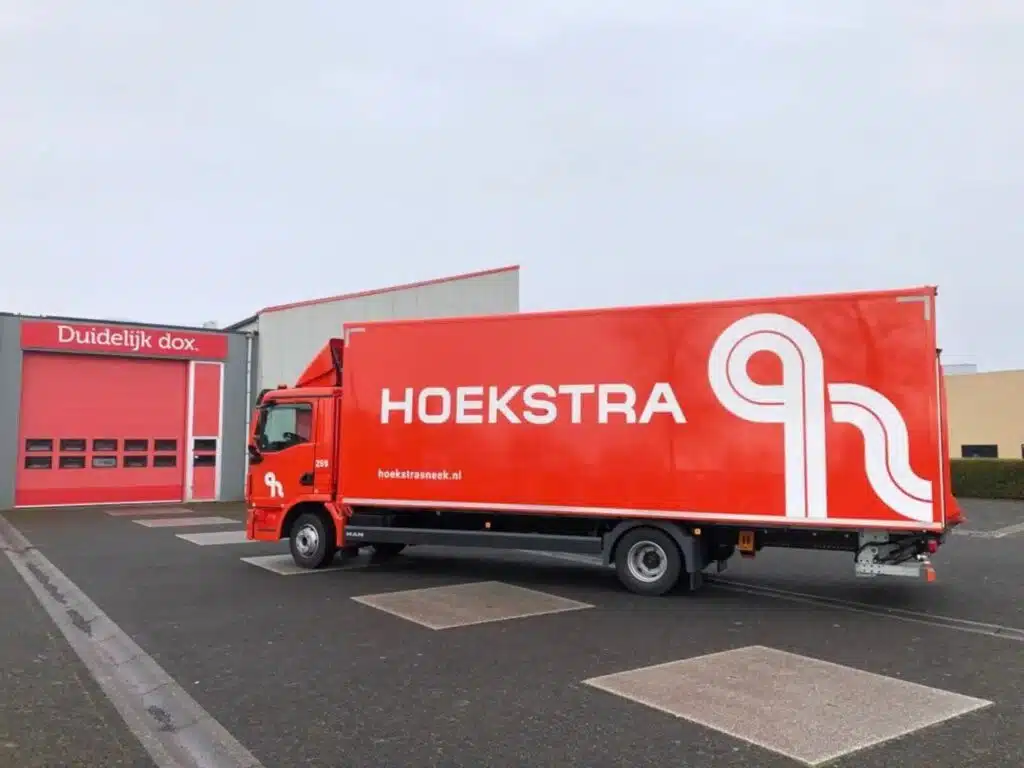 Schone rode vrachtwagen met bakwagenreclame van Hoekstra Sneek, professioneel uitgevoerd door Dox in Joure.