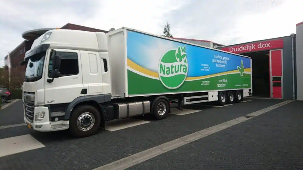 DAF-vrachtwagen met opvallende trailerreclame van Natura voor duurzaam frituren, uitgevoerd door reclamebedrijf Dox.